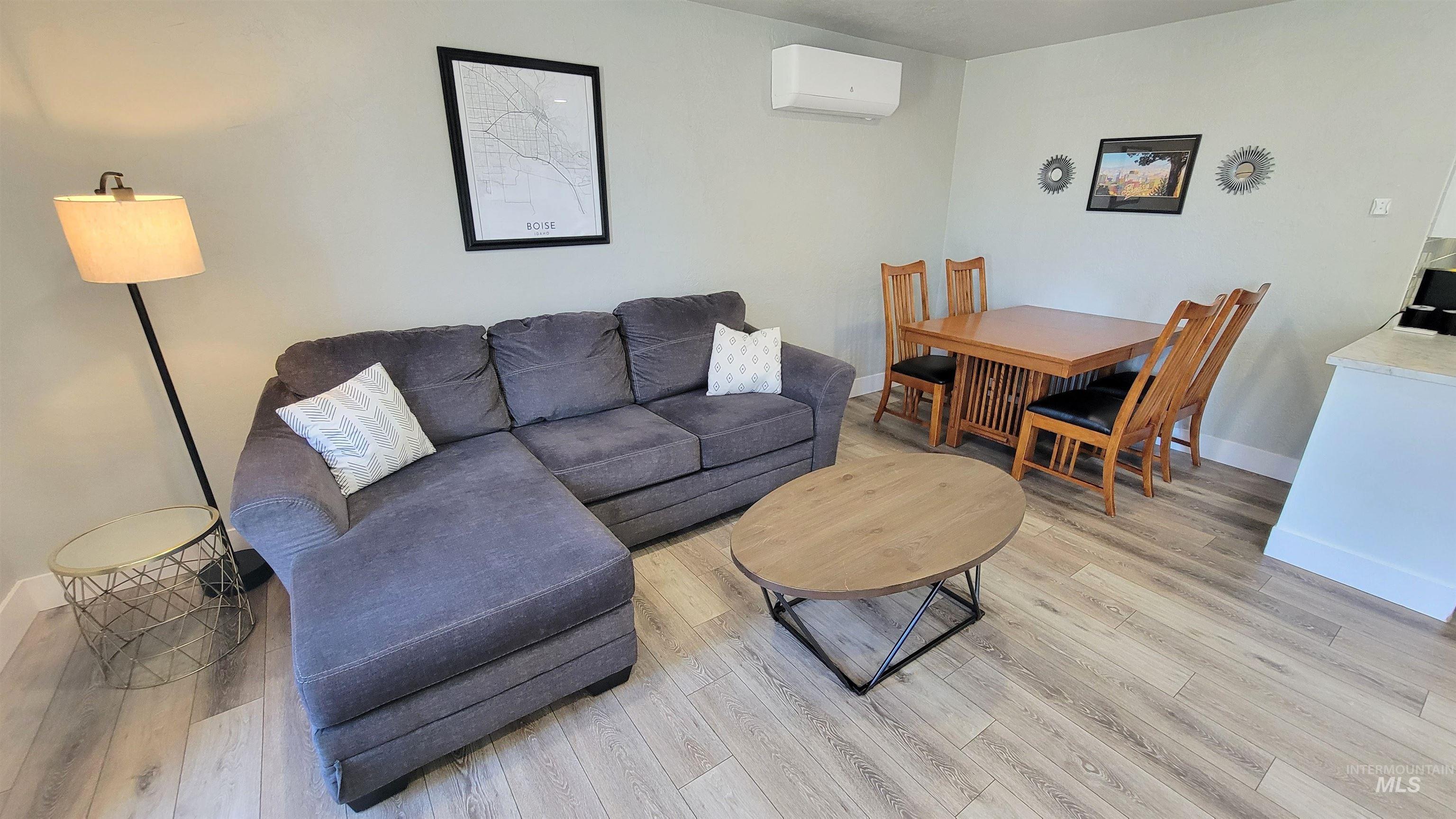 814 Baker Street Boise, ID 83706 - Photo 20 of 26 Open-concept living space featuring wood-finish flooring, a wall-mounted mini-split HVAC system, and light-toned wall paint