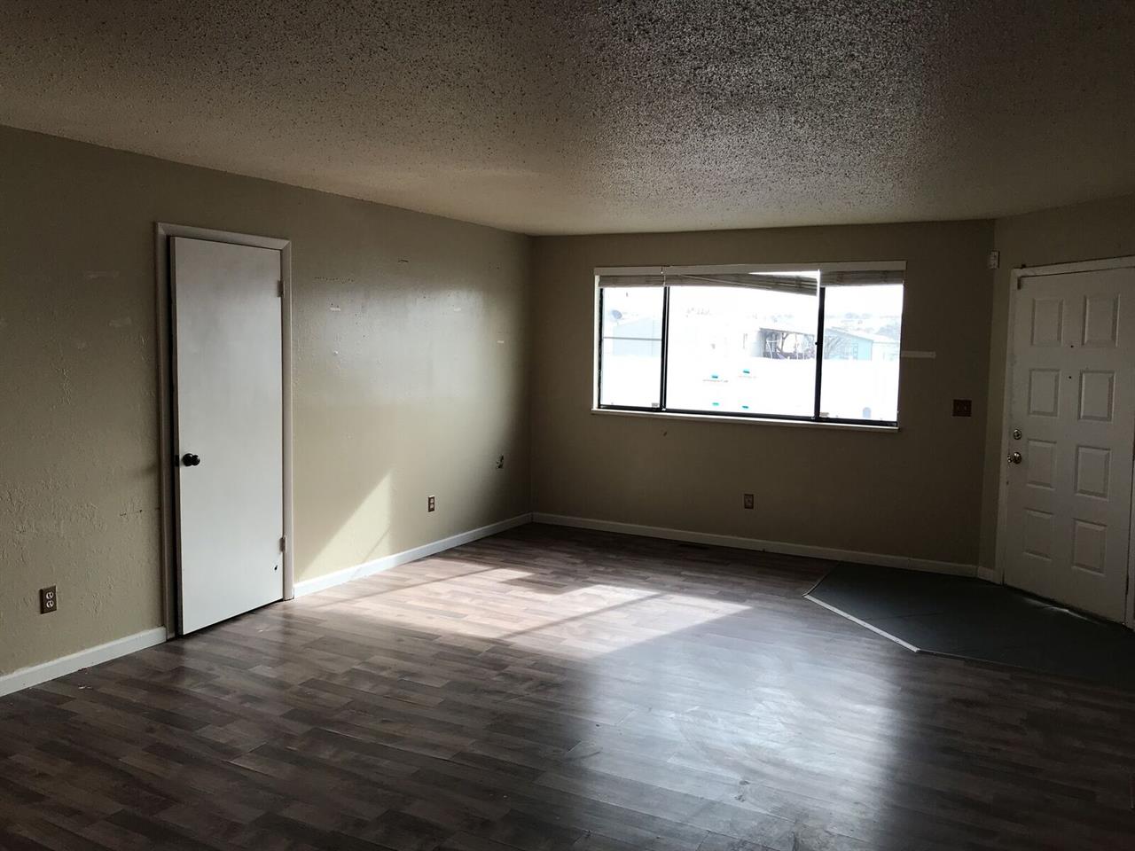 3240 D D 1/4 Road, Unit A&B Clifton, CO 81520 - Photo 5 of 19 an empty room with wooden floor and windows
