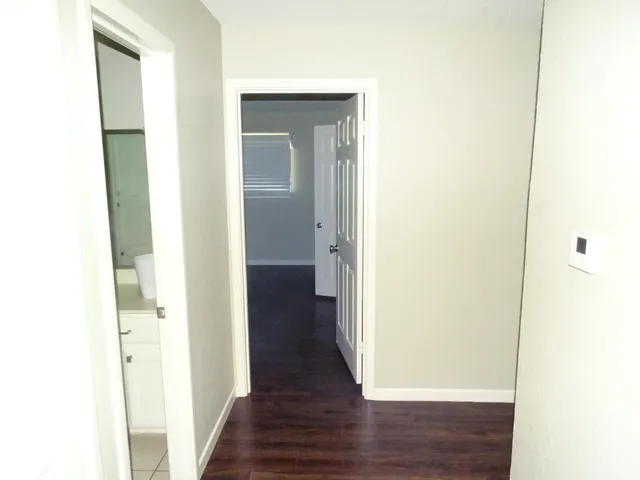 a view of a hallway with wooden floor