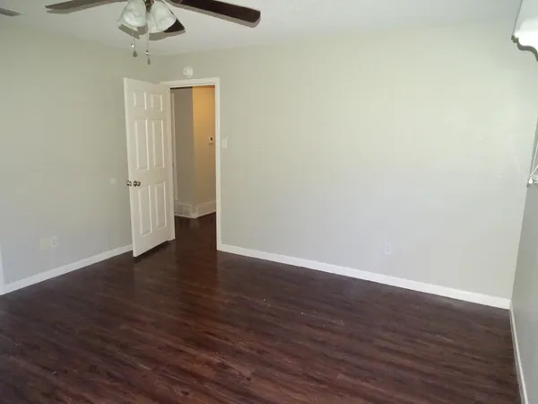 a view of an empty room with wooden floor