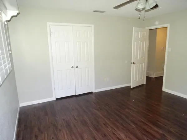 a view of an empty room with wooden floor
