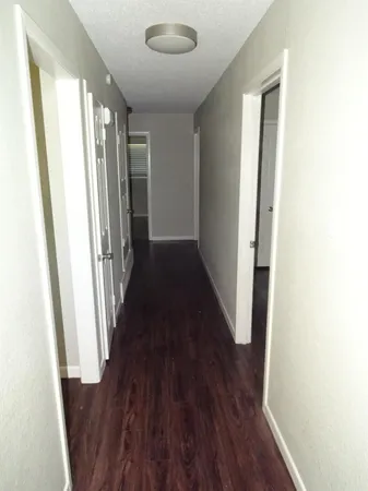 a view of a hallway with wooden floor