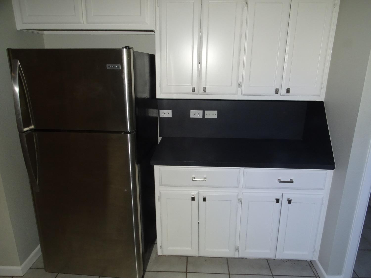 4920 17th Street Lubbock, TX 79416 - Photo 7 of 33 a view of kitchen with refrigerator and wooden cabinets