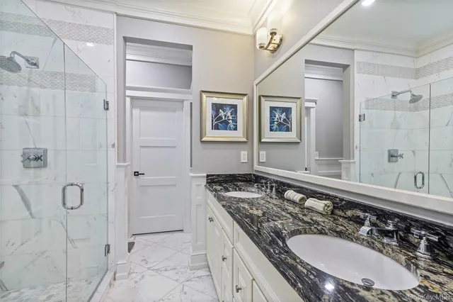 a bathroom with a granite countertop sink a mirror and shower