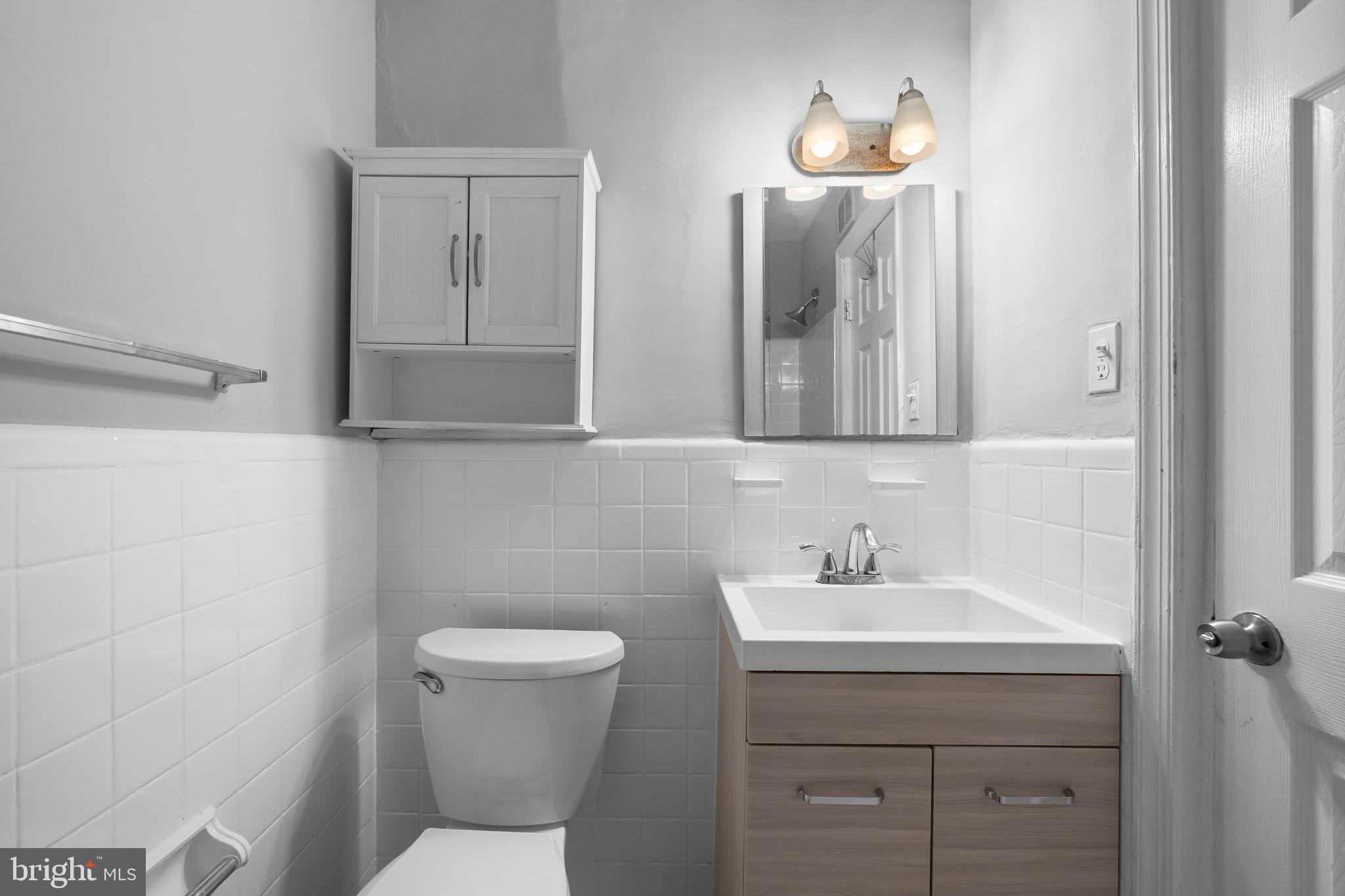 1238 Simms Place Northeast, Unit A Washington, DC 20002 - Photo 10 of 16 a bathroom with a toilet sink and mirror