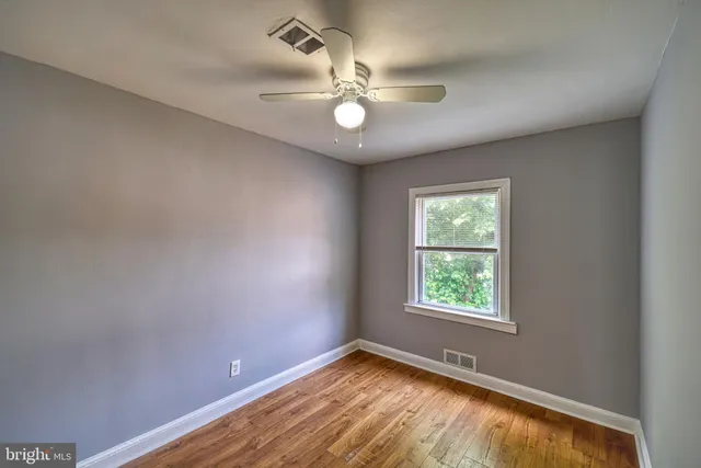 an empty room with wooden floor and door