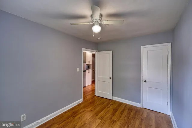 an empty room with a window and a ceiling fan
