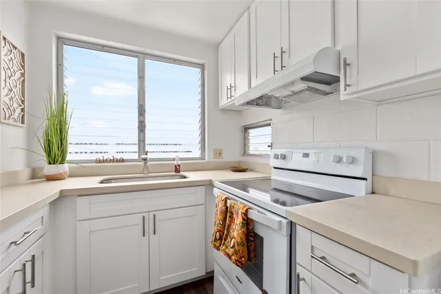 a kitchen with white cabinets and white appliances