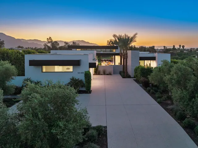 a living room with furniture and potted plants