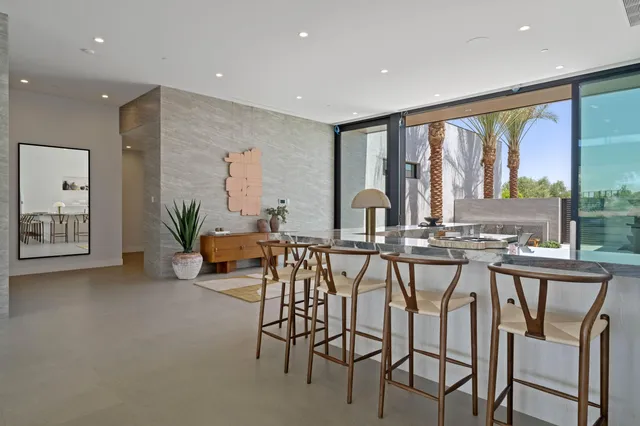 a living room with furniture kitchen view and large windows