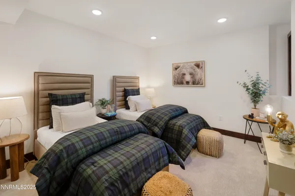 a bedroom with two beds and potted plant