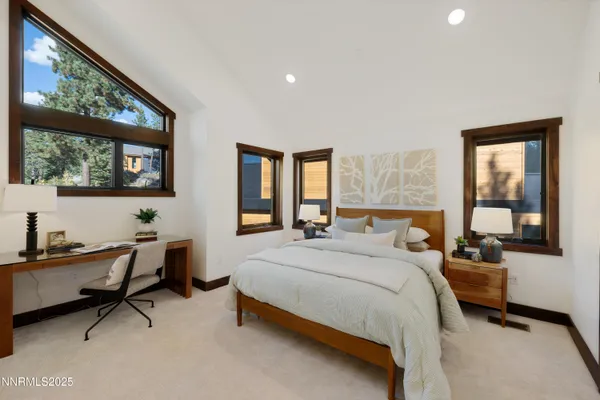 a bedroom with a bed a desk and chair with mirror