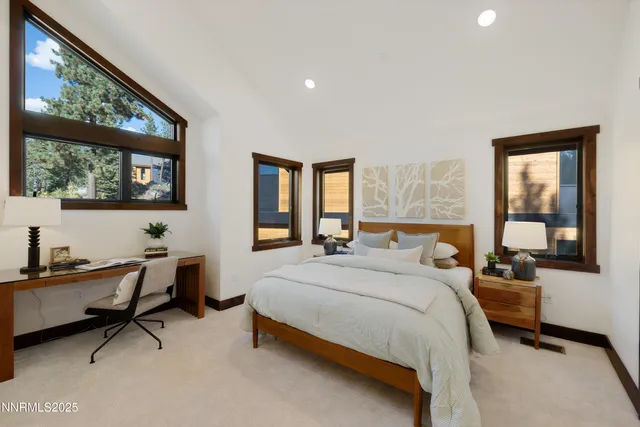 a bedroom with a bed a desk and chair with mirror