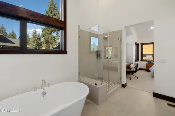 a bathroom with a tub sink shower and mirror