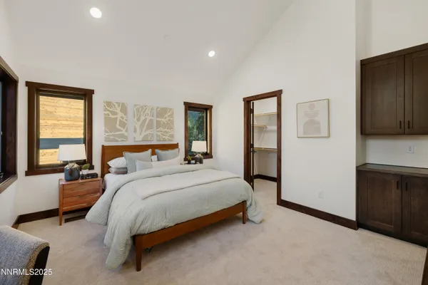 a bedroom with a bed couch and a dresser next to a window