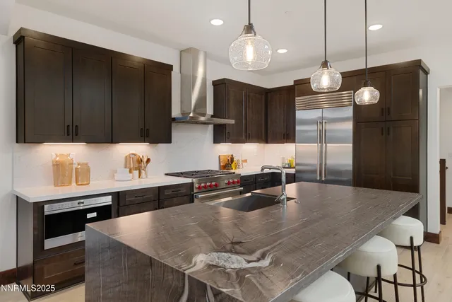 a kitchen with kitchen island granite countertop a sink a center island and cabinets