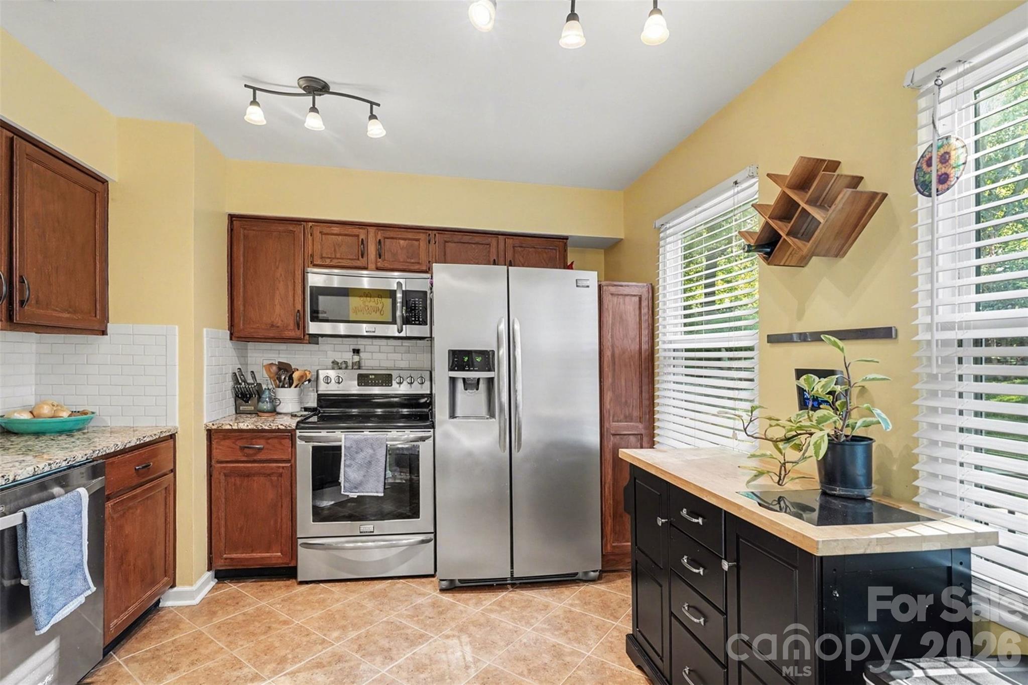 12213 Woodside Falls Road Pineville, NC 28134 - Photo 11 of 28 a kitchen with stainless steel appliances granite countertop a sink a stove and a refrigerator