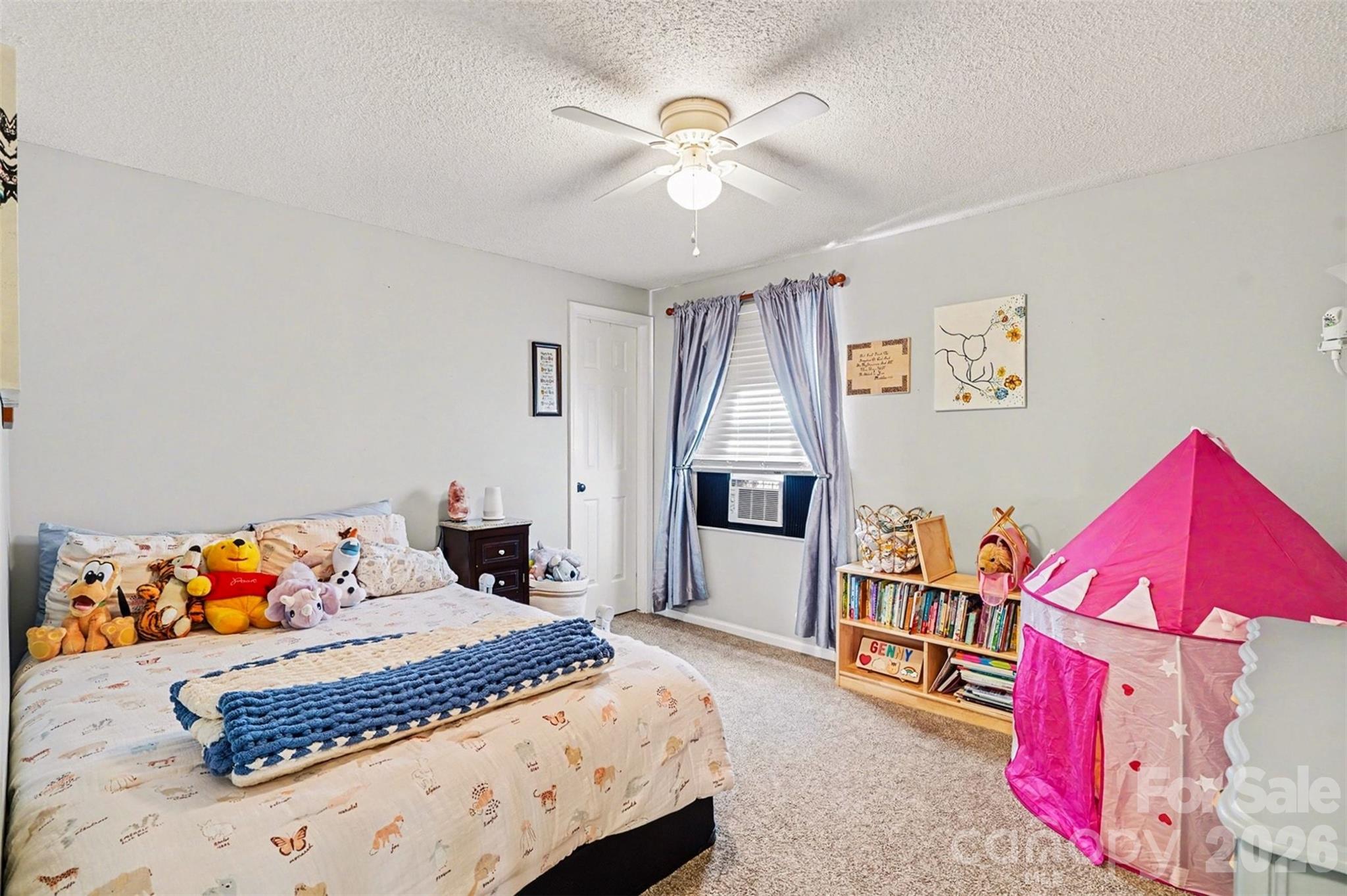 12213 Woodside Falls Road Pineville, NC 28134 - Photo 16 of 28 a bedroom with a bed and a chandelier