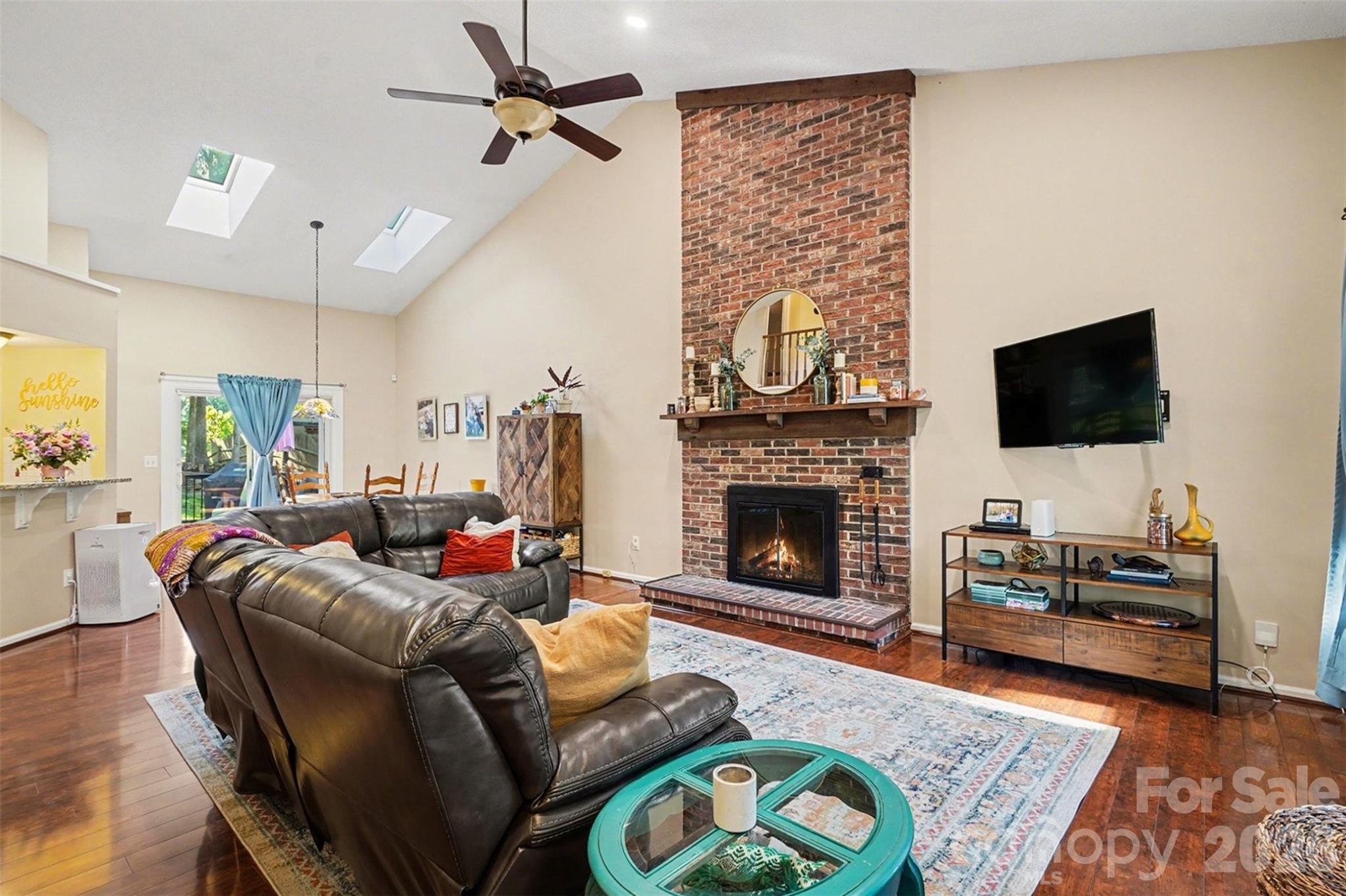12213 Woodside Falls Road Pineville, NC 28134 - Photo 7 of 28 a living room with furniture a flat screen tv and a fireplace