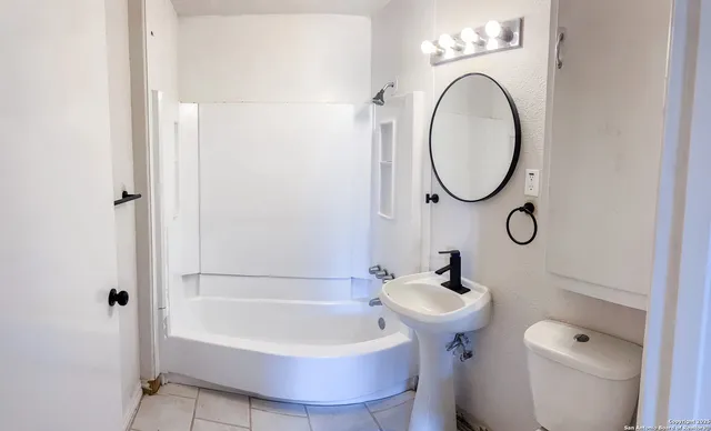 a bathroom with a sink a toilet and a mirror