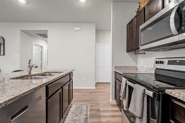 a kitchen with granite countertop stainless steel appliances and wooden cabinets