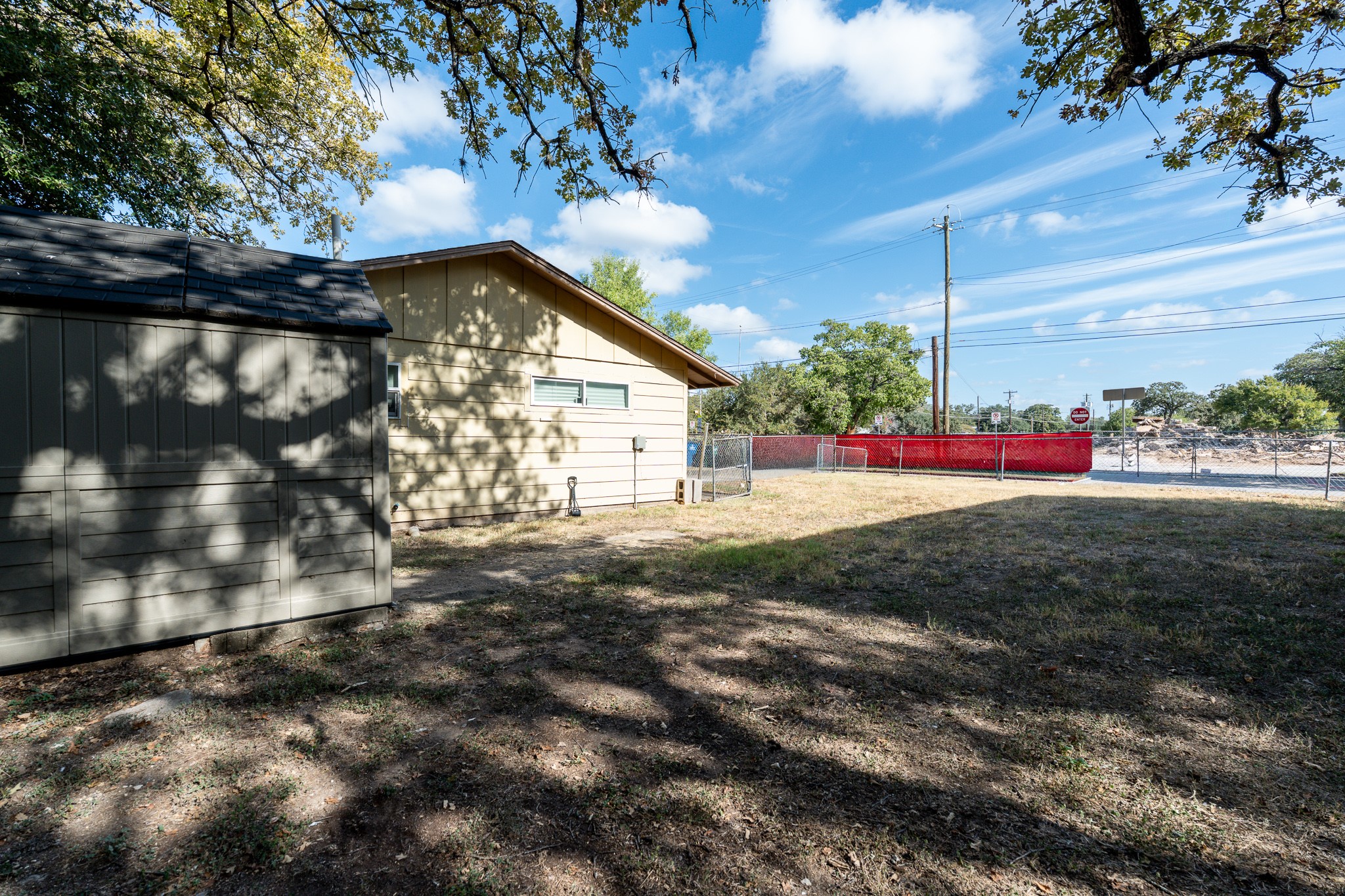 701 Vargas Road Austin, TX 78741 - Photo 4 of 13 A spacious grassy yard provides plenty of outdoor potential alongside a detached storage shed.