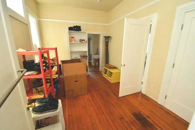 a view of a hallway with wooden floor and furniture