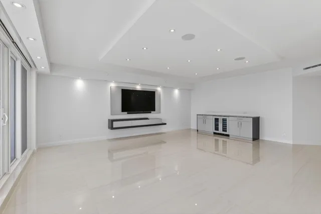 a bedroom with a large bed a flat screen tv and a large window