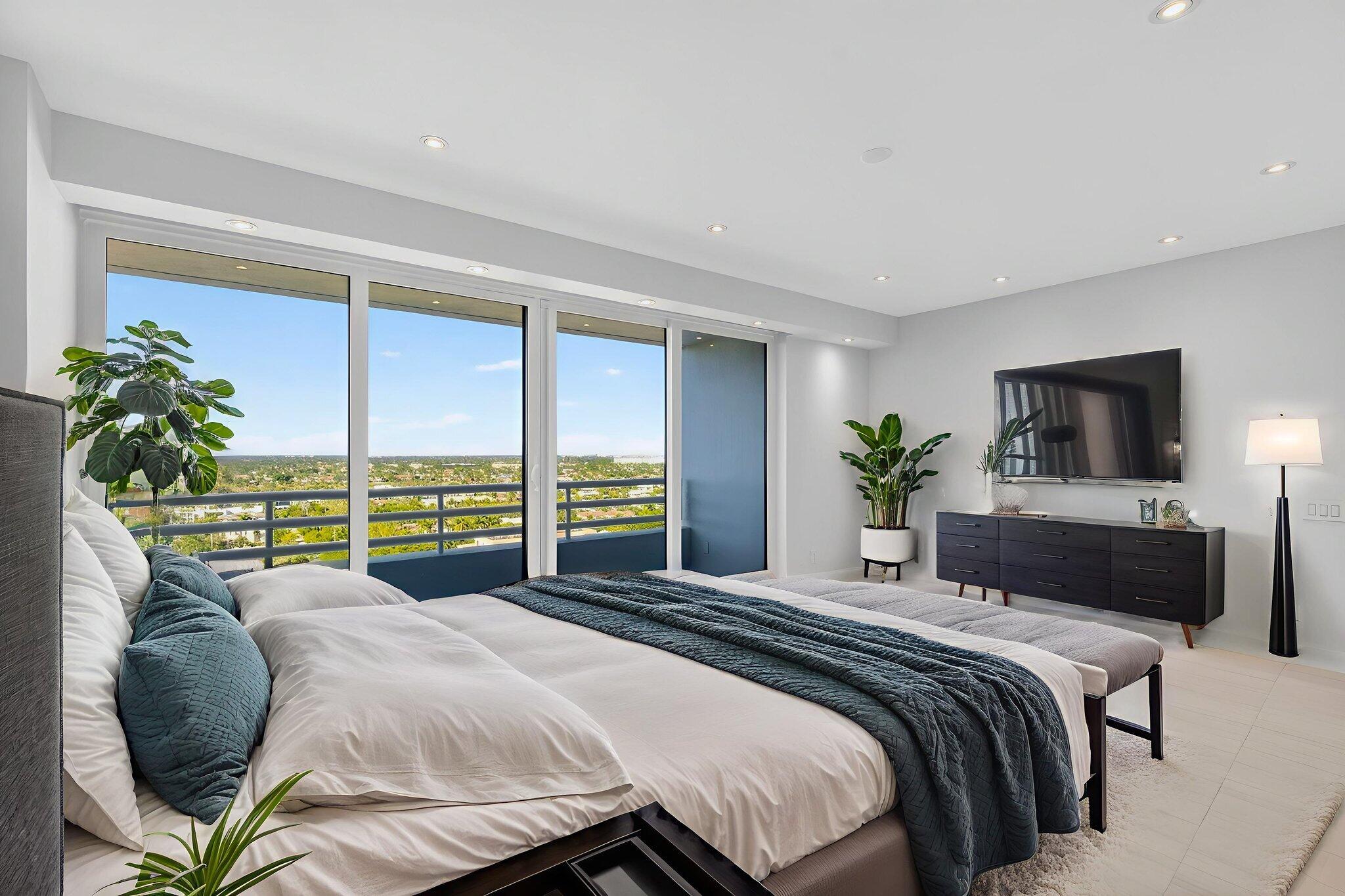 1500 South Ocean Boulevard, Unit 1602 Boca Raton, FL 33432 - Photo 35 of 88 a bedroom with a large bed a flat screen tv and a large window