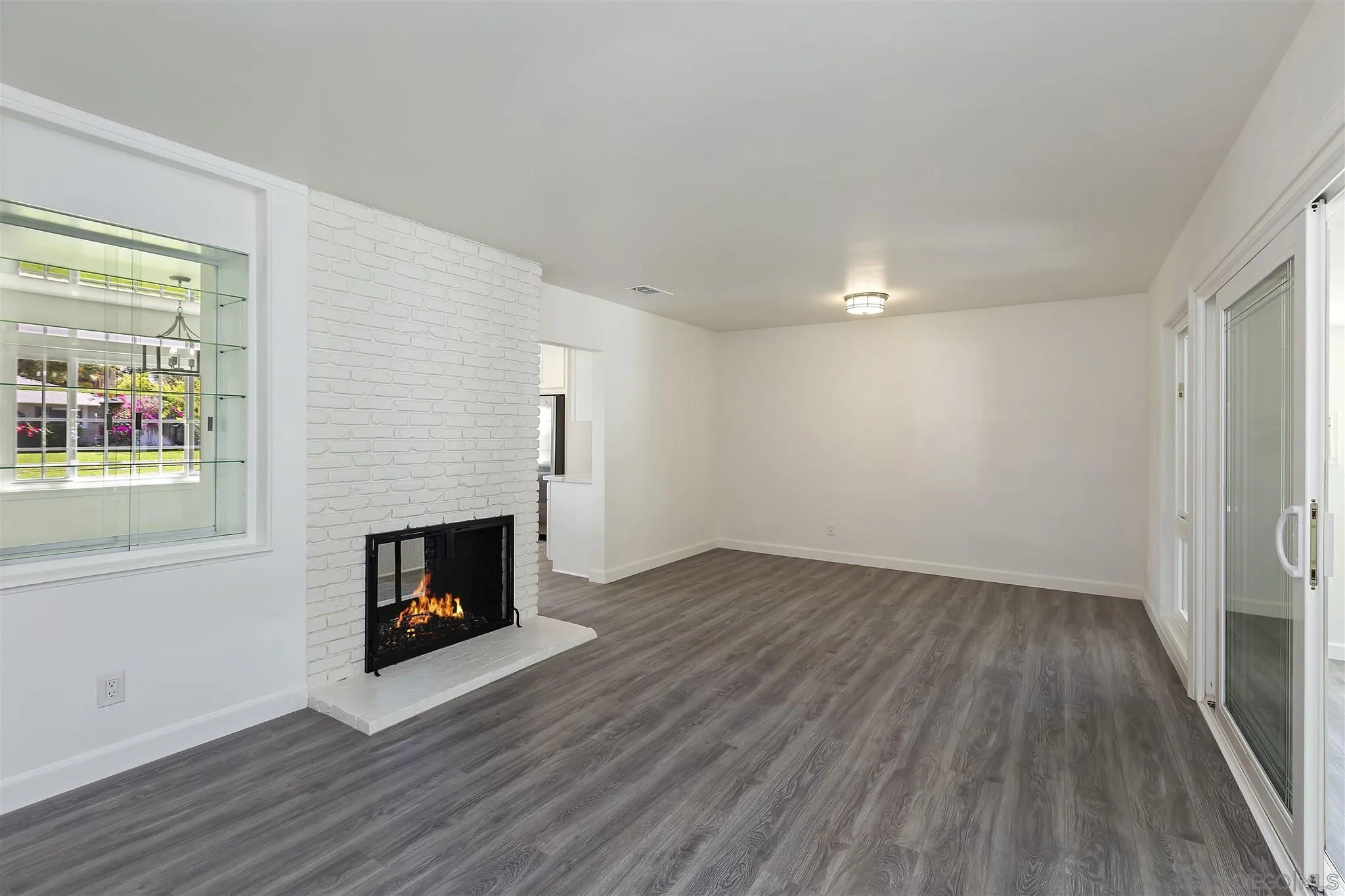 2956 Ronald Street Riverside, CA 92506 - Photo 10 of 28 an empty room with wooden floor fireplace and windows