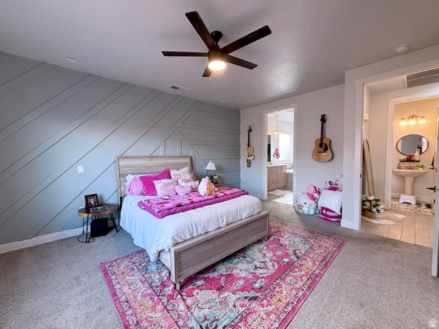 429 East Treasure Road Washington, UT 84780 - Photo 26 of 36 Bedroom with ensuite bathroom, a ceiling fan, an accent wall, carpet floors, and wooden walls