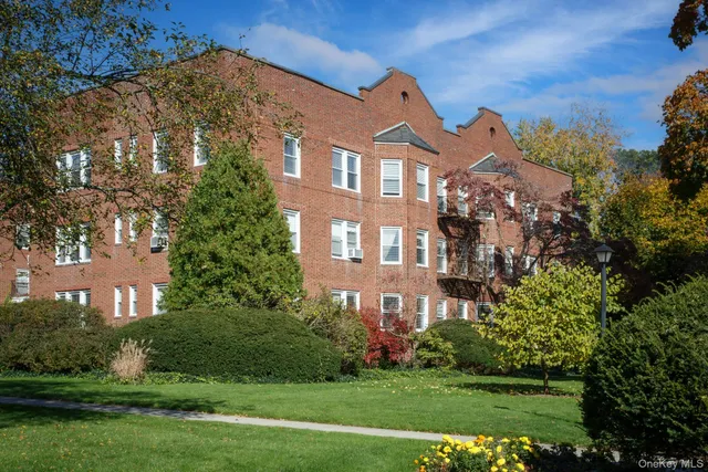 a view of a brick building next to a yard