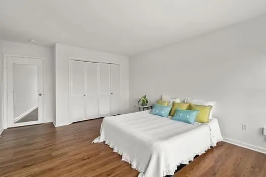 a bedroom with a bed and wooden floor
