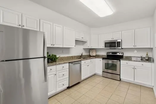 a kitchen with white cabinets and white stainless steel appliances