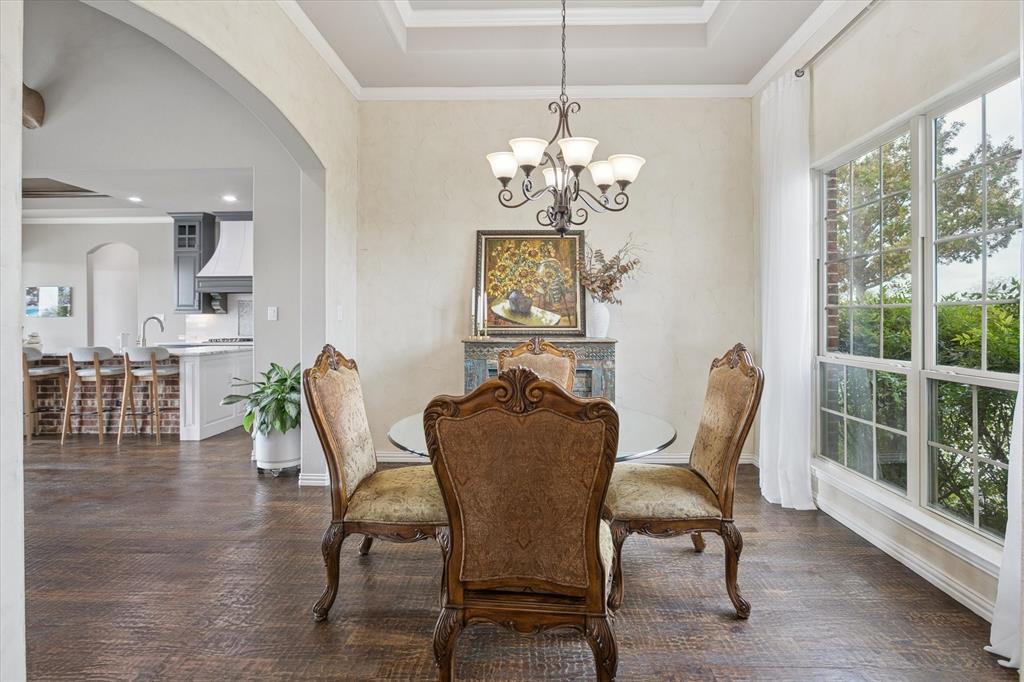 542 Pierce Road Red Oak, TX 75154 - Photo 8 of 27 Tray ceiling with decorative molding, wood-finish flooring, and an arched doorway leading to the kitchen