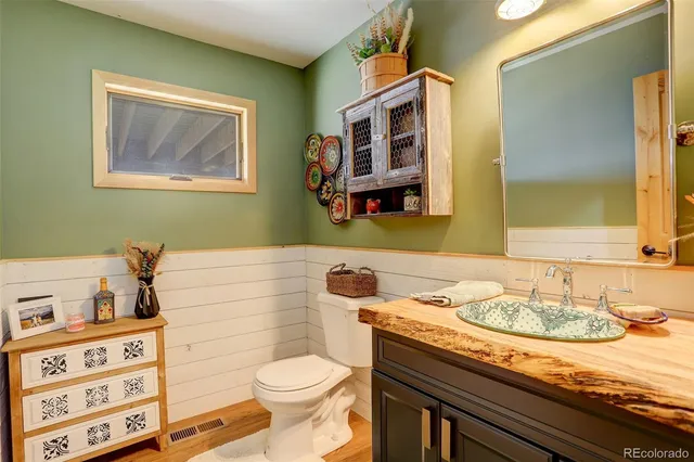 a bathroom with a granite countertop toilet sink and mirror