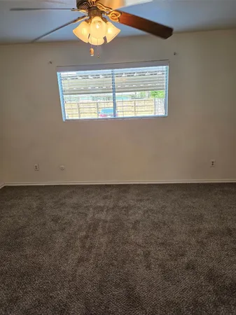 a view of an empty room with a chandelier fan