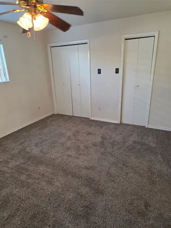 an empty room with closet and wooden door