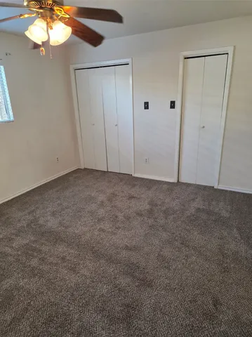 an empty room with closet and wooden door