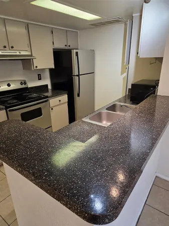 a kitchen with a refrigerator and a stove
