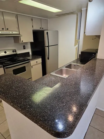 a kitchen with a refrigerator and a stove