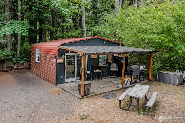 a backyard of a house with barbeque oven table and chairs