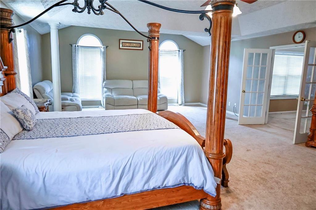 5964 Springfair Run Lithonia, GA 30038 - Photo 23 of 40 a bedroom with a bed a mirror and a large window