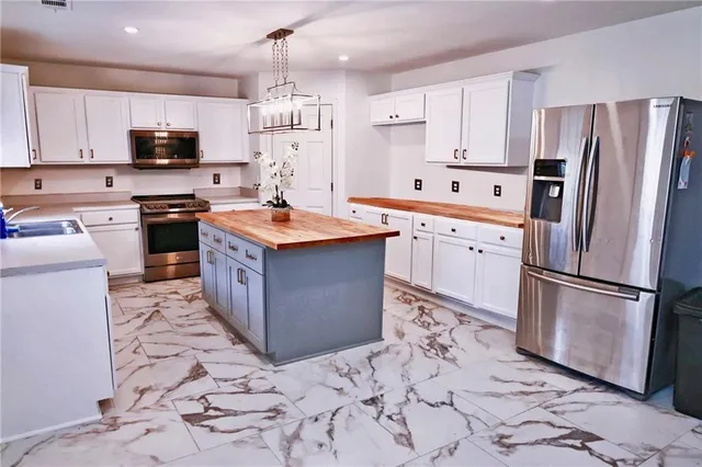 a kitchen with stainless steel appliances granite countertop a refrigerator stove a sink and dishwasher