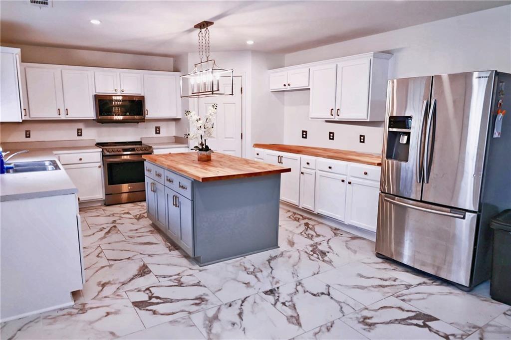 5964 Springfair Run Lithonia, GA 30038 - Photo 9 of 40 a kitchen with stainless steel appliances granite countertop a refrigerator stove a sink and dishwasher