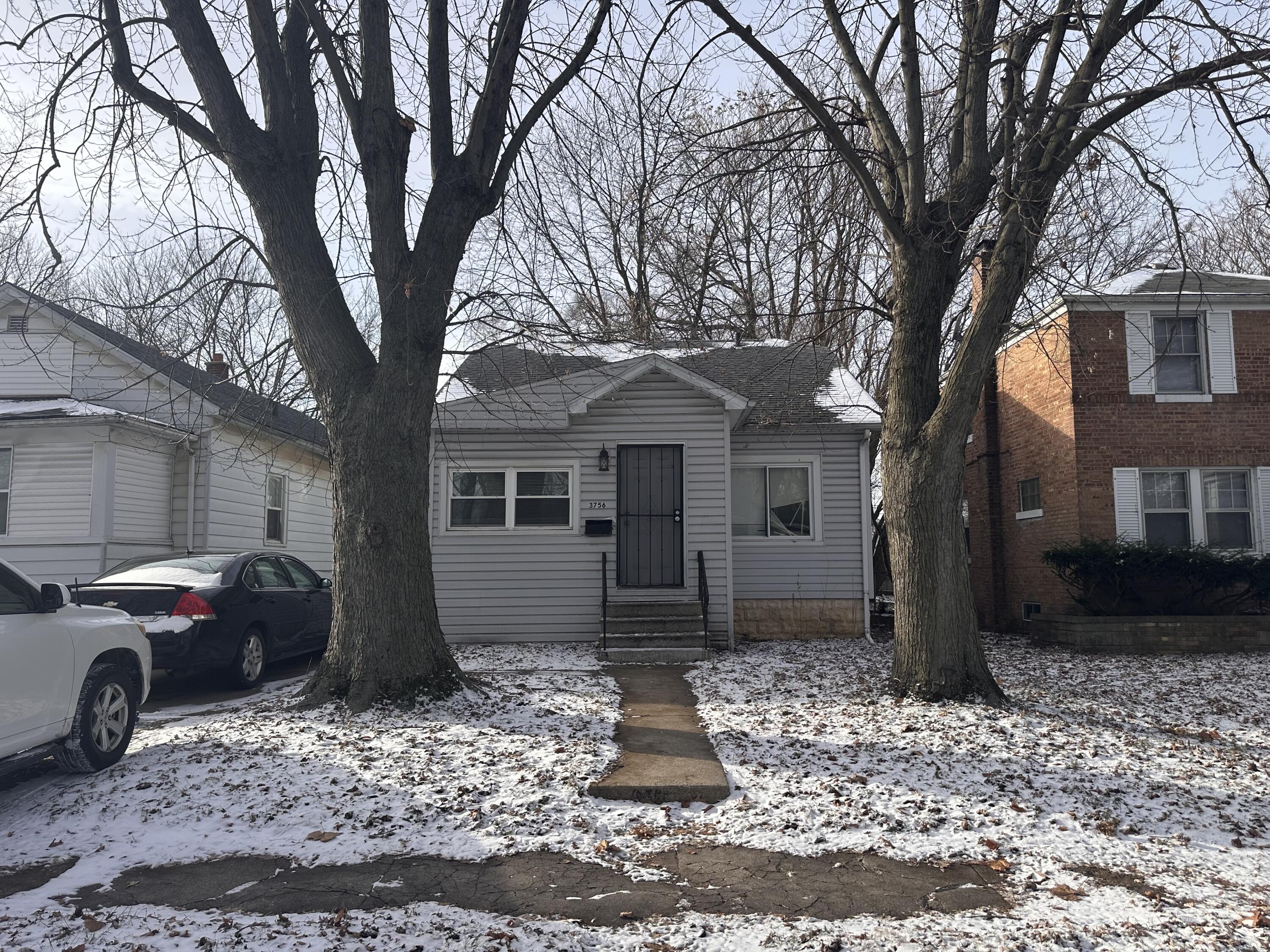 3756 Tyler Street Gary, IN 46408 - Photo 1 of 12 a front view of a house with a yard covered in snow