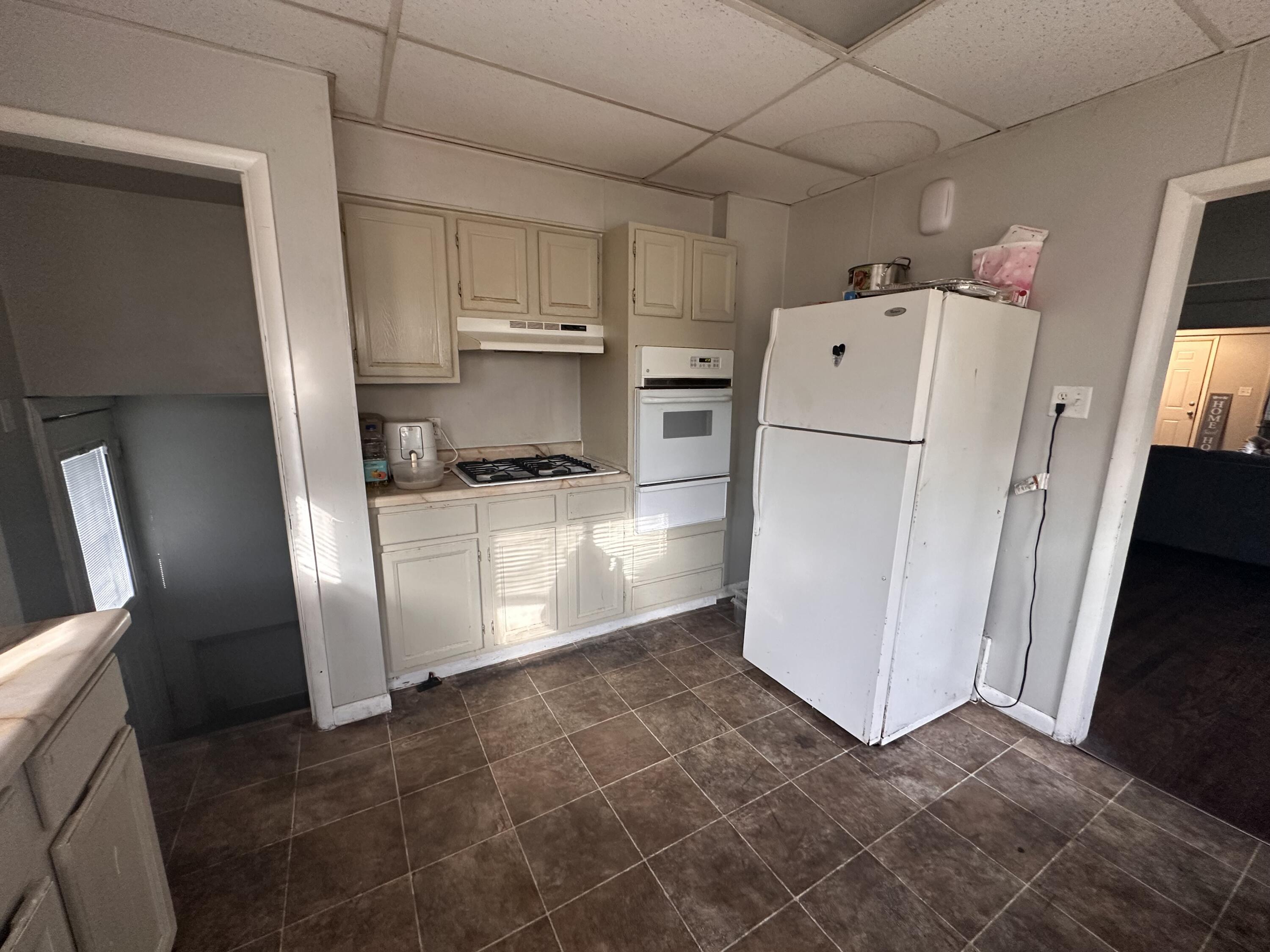 3756 Tyler Street Gary, IN 46408 - Photo 10 of 12 a kitchen with a refrigerator a stove top oven and cabinets