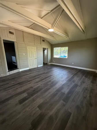 a view of a room with wooden floor and windows