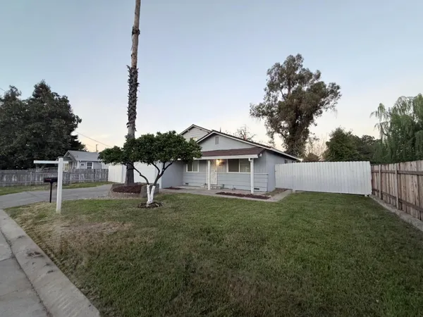 a white house that has a tree in front of it