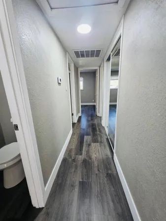 a view of a hallway with wooden floor and staircase
